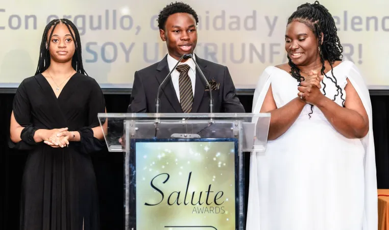 Two students and advisor share the stage