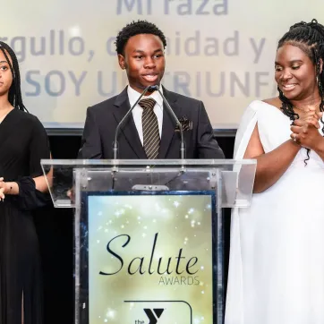 Two students and advisor share the stage