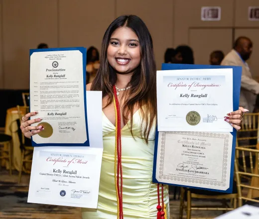 Black and Latino Achiever holds up many certificates of achievement