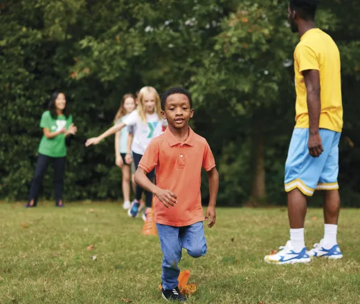 Young children run to complete an obstacle course outside that was set up and monitored by Y staff members.